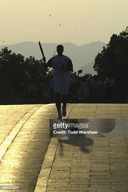 Yao Ming of the NBA Houston Rockets carries the Olympic Flame at the Summer Palace during Day 6 of the ATHENS 2004 Olympic Torch Relay on June 9,...
