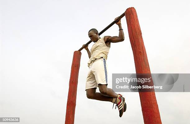 Senegalese man does pull-ups along the beach June 7, 2004 in Dakar, Senegal. Hundreds of young Senegalese men, many of them students, gather every...