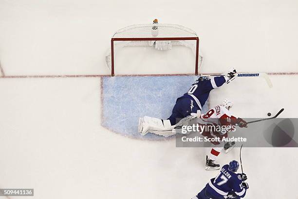 Goalie Ben Bishop of the Tampa Bay Lightning stretches to make a save against Joakim Andersson of the Detroit Red Wings during the third period at...