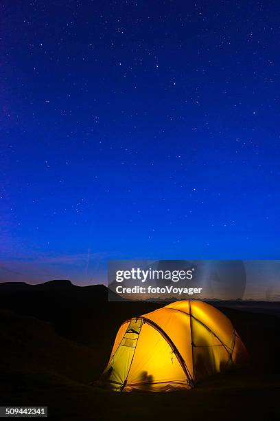 stars scheint über warm leuchtende zelt und bergen versinkenden - base camp stock-fotos und bilder