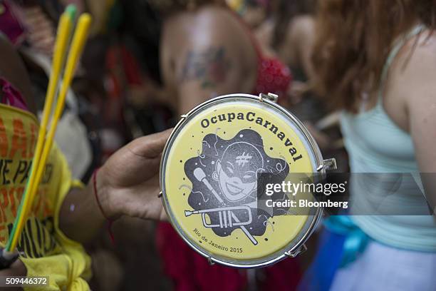 Reveler plays a small drum that reads "Occupy Carnival" during the Bloco das Mulheres Rodadas Carnival parade in Rio de Janeiro, Brazil, on...