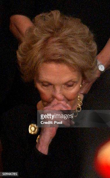 Former first lady Nancy Reagan sheds a tear near the casket of her husband, former U.S. President Ronald Reagan, during his state funeral on Capitol...