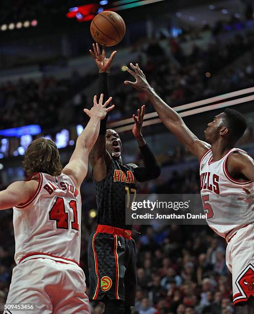 Dennis Schroder of the Atlanta Hawks shoots over Cameron Bairstow and Bobby Portis of the Chicago Bulls at the United Center on February 10, 2016 in...