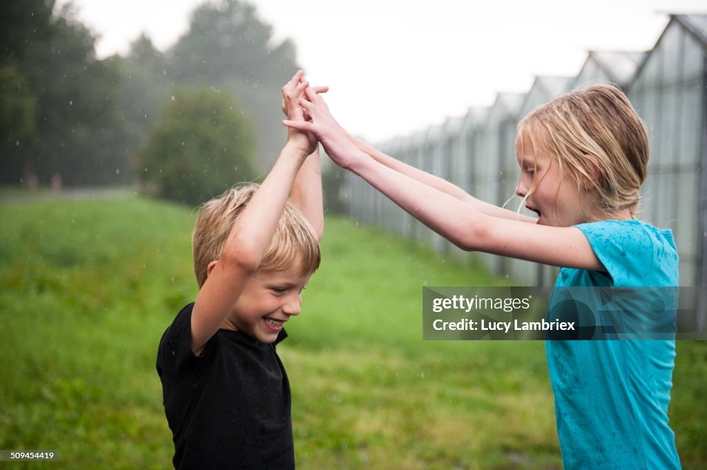 Boy and girl playing in the rain