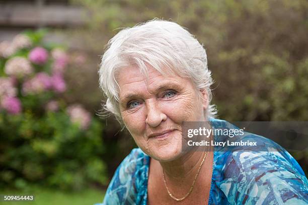 portrait of a senior woman in her garden - 65 69 ans stock-fotos und bilder