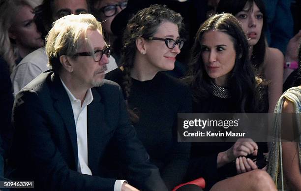 Actor Gary Oldman, Gisele Schmidt and actress Demi Moore, in Saint Laurent by Hedi Slimane, attend Saint Laurent at the Palladium on February 10,...