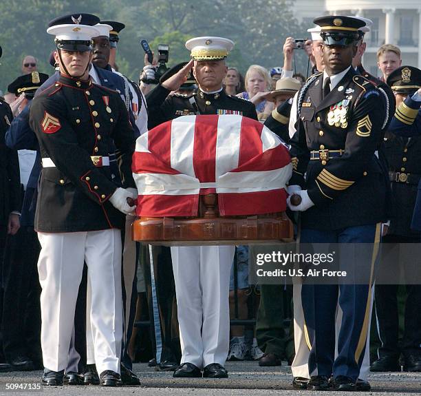 Marine Corps Commandant Gen. Michael W. Haggee salutes as the flag draped casket bearing former President Ronald Reagan's remains is moved to a horse...