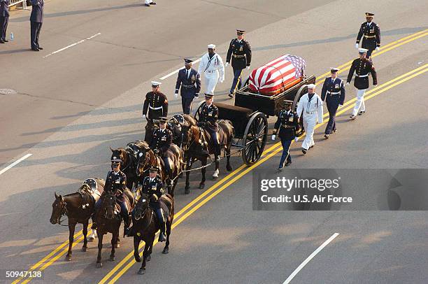 Members of the honor guard escort the caisson with the remains of former President Ronald Reagan's flag draped casket during the funeral procession...