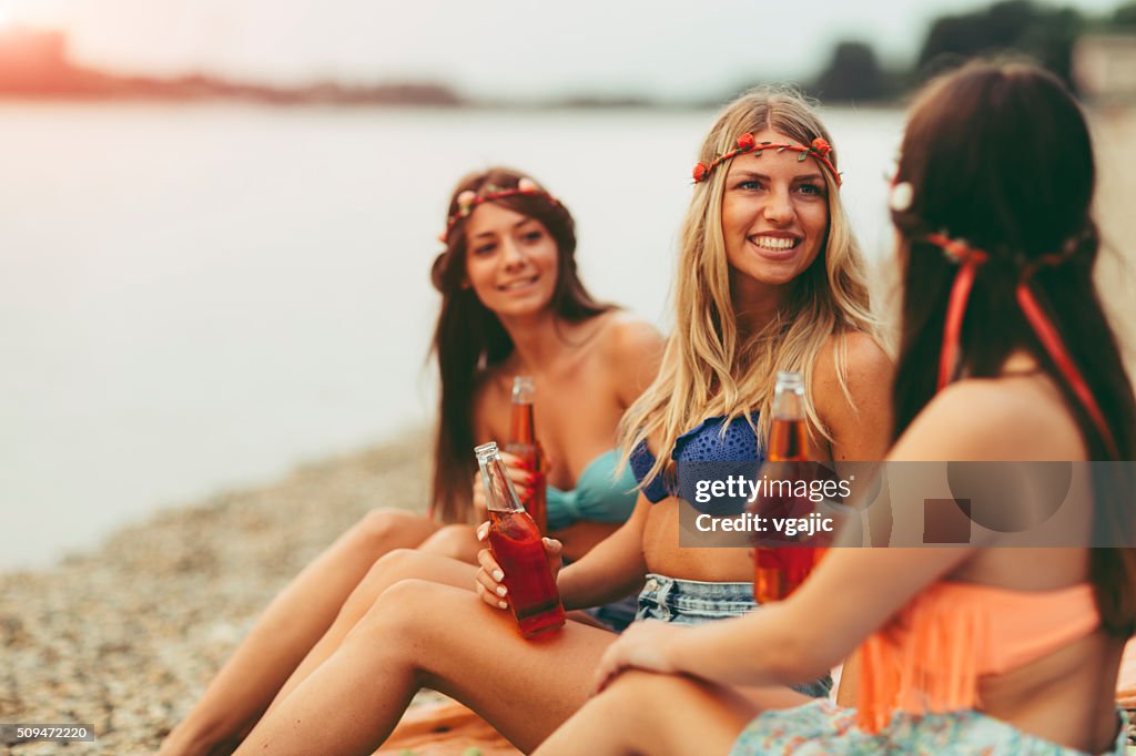 Junge Frauen Anstoßen mit Flaschen am Strand