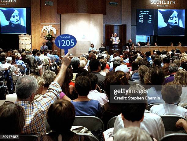 Bidder holds up his bidding sign during the Katharine Hepburn auction at Sotheby's June 10, 2004 in New York City. Property from the estate of the...