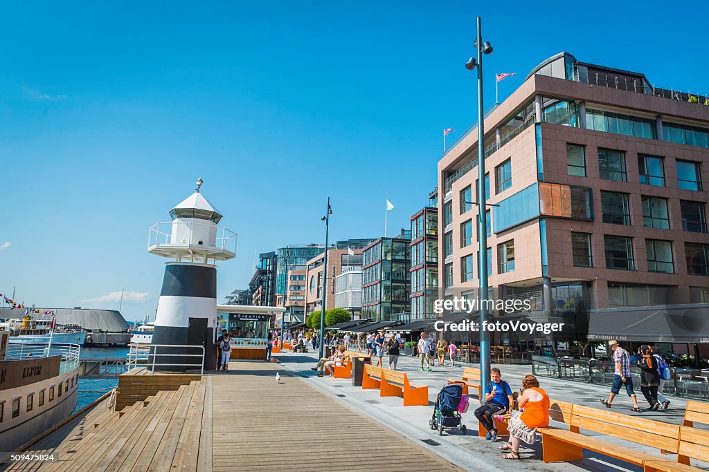 Oslo people enjoying summer sunshine on Aker Brygge waterfront Norway