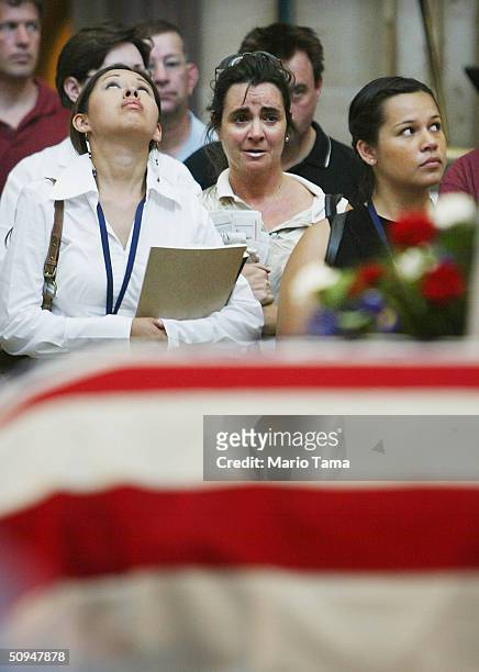 Visitors pay their respects at former President Ronald Reagan's casket inside the U.S. Capitol June 10, 2004 in Washington, DC. Reagan's body will...