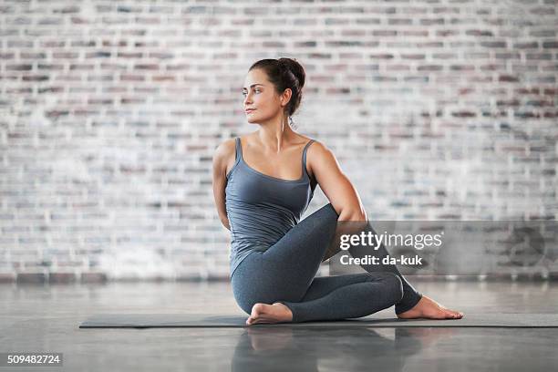 young woman doing yoga meditation and stretching exercises - pilates stock pictures, royalty-free photos & images