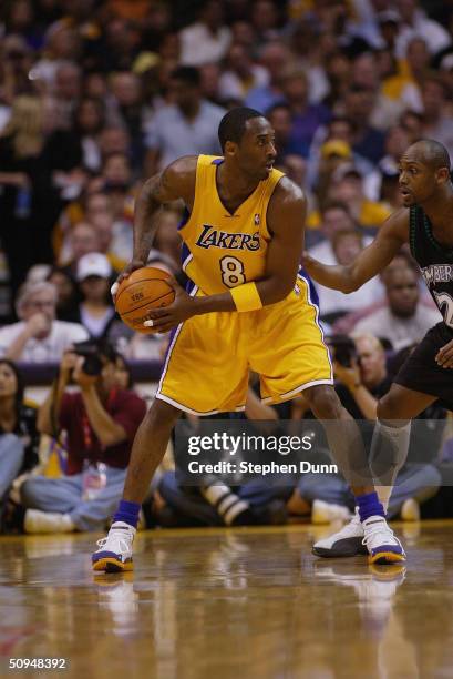 Kobe Bryant of the Los Angeles Lakers looks to play the ball against Trenton Hassell of the Minnesota Timberwolves in Game 4 of the Western...