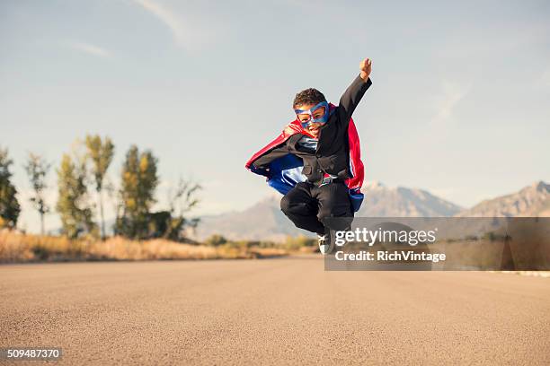 young boy wearing superhero costume and business suit is jumping - super excited suit stock pictures, royalty-free photos & images