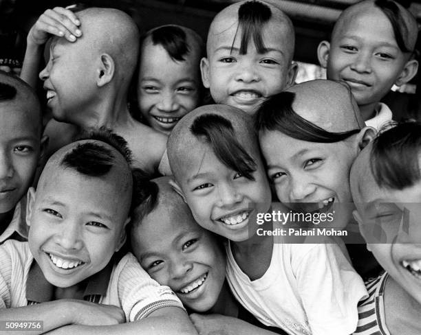 Children who have lost both of the parents to AIDS have a fun moment in front of the camera May 26, 2004 in Battambong, Cambodia. A monk named "Mony"...