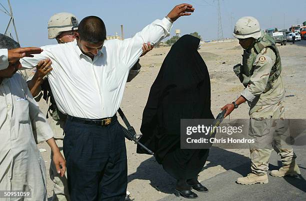 Soldiers with the 2nd Armoured Cavalry Regiment make security checks on Iraqis at a check point on June 11, 2004 in Najaf, Iraq. Tensions remain high...