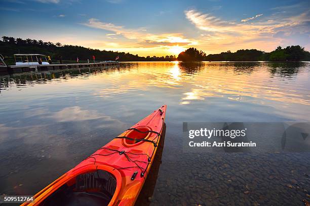 canoe on water during sunset - cottage water stock pictures, royalty-free photos & images