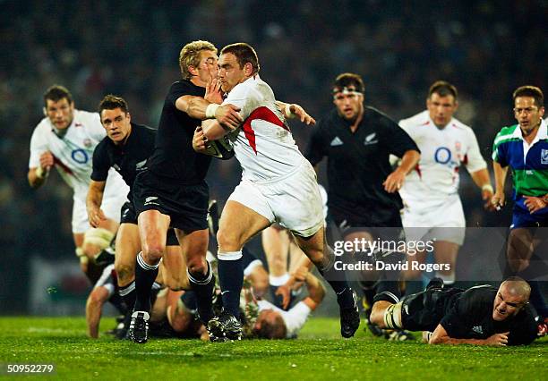 Trevor Woodman, the England prop, charges past Justin Marshall during the New Zealand v England rugby union international at Carisbrook Stadium on...