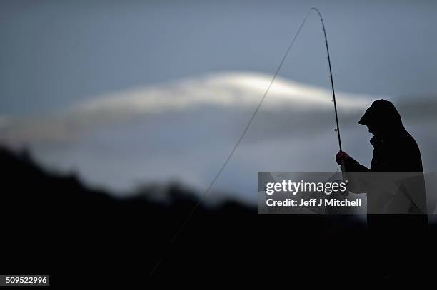 An angler fishes during the opening day of the salmon season on the River Spey on February 11, 2016 in Aberlour, Scotland. The annual opening day...