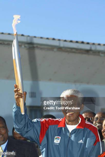 Nelson Mandela holds the Olympic Flame on Robben Island during Day 9 of the ATHENS 2004 Olympic Torch Relay June 12, 2004 in Cape Town, South Africa....