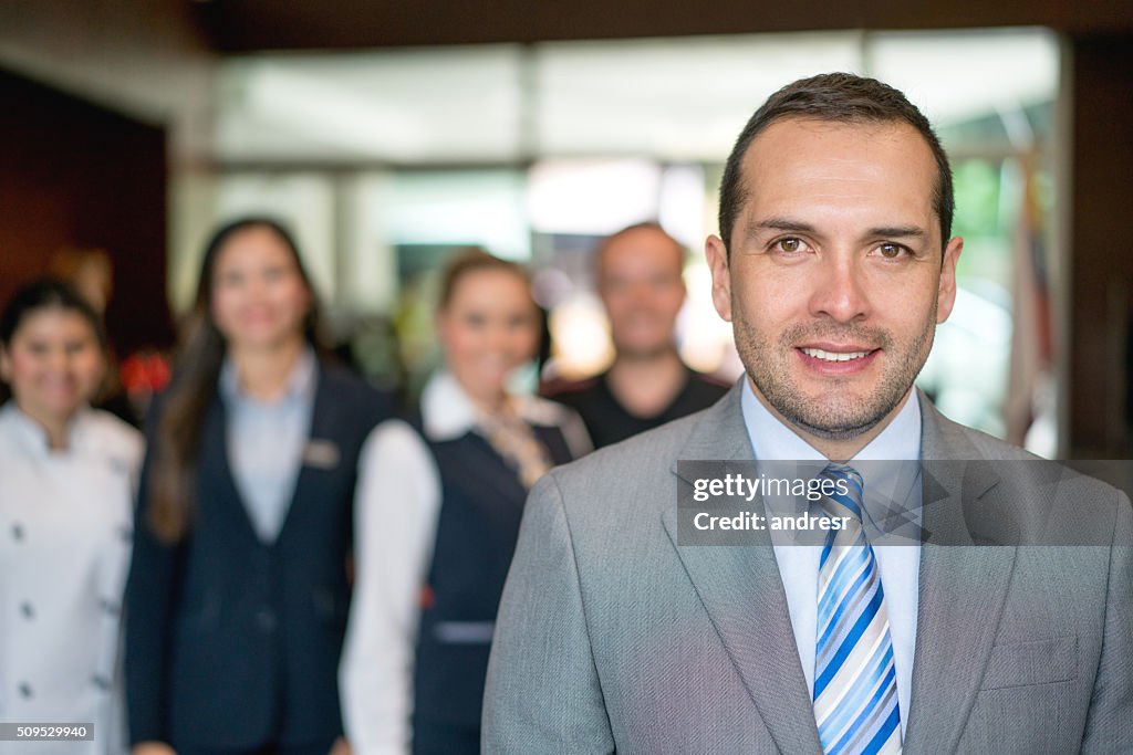 Directeur de l’hôtel avec le personnel en arrière-plan