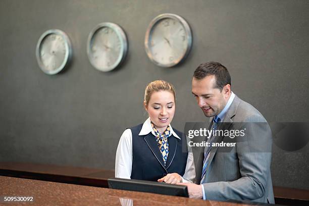 el gerente del hotel hablando con la mujer en la recepción - turismo responsable fotografías e imágenes de stock