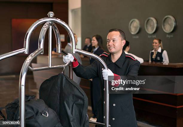 bellboy working at a hotel - bellhop stock pictures, royalty-free photos & images