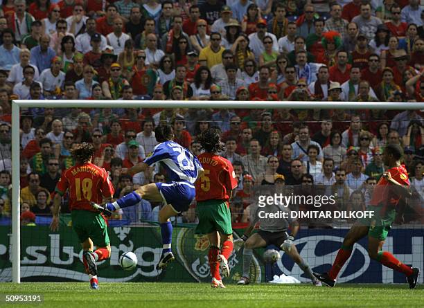 Greece's midfielder Georgios Karagounis looks at the ball after kicking to score next to Portugal's defender Fernando Couto 12 June 2004 at Dragao...