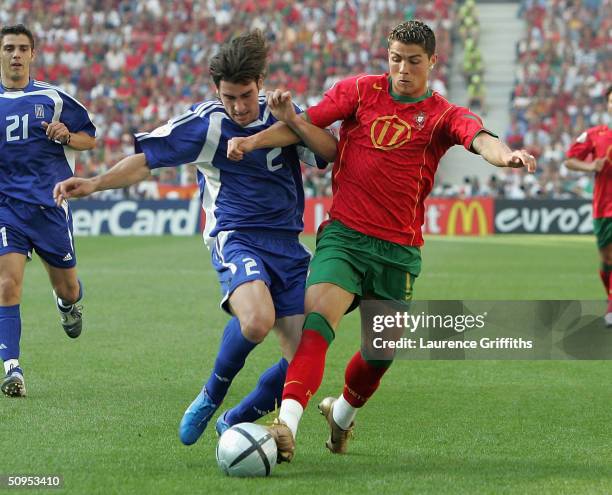 Cristiano Ronaldo of Portugal clashes with Georgios Seitardis of Greece during the Portugal v Greece Group A opening match the 2004 UEFA European...