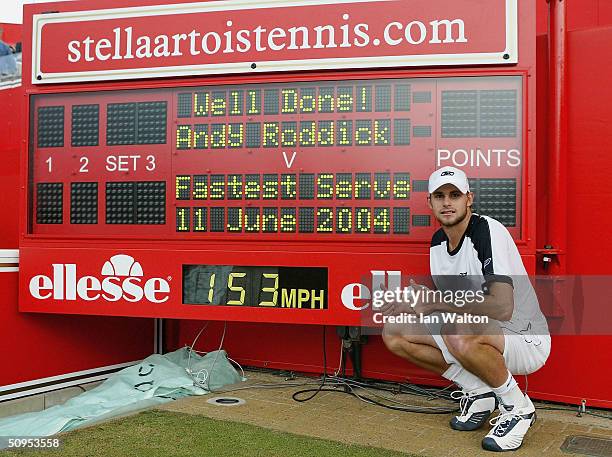 Andy Roddick of the USA poses next to the official scoreboard showing his world record serve speed after his victory over Lleyton Hewitt of Australia...
