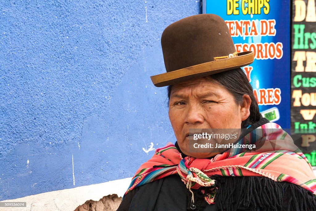 Peru: Quechua Woman in Bowler Hat (Close-Up); Blue Wall Background