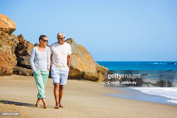 senior coppia afro-americana cammina sulla spiaggia - zuma beach foto e immagini stock