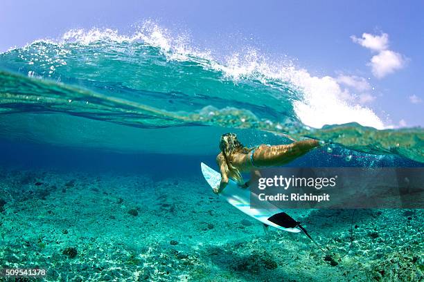 over under of girl duckdive an oncoming wave - duck dive stock pictures, royalty-free photos & images