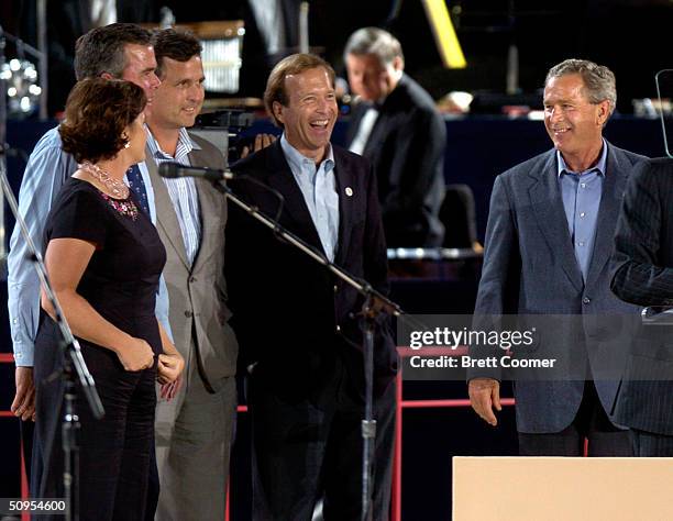 President George W. Bush walks onto the stage while his siblings Dorothy, Jeb, Marvin and Neil look on before speaking in honor of their father,...