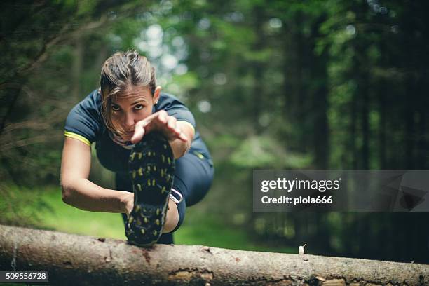 woman athlete stretching in the forest after running - cross country running 個照片及圖片檔