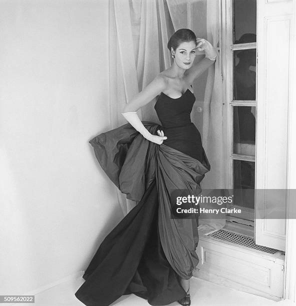 Model wearing Schiaparelli's evening dress with navy blue taffeta three-pointed bodice over a skirt wrapped and tied with a Venus de Milo drapery of...