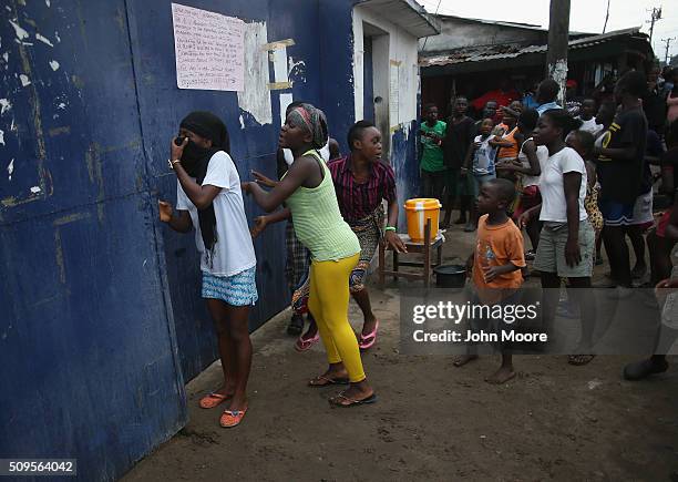 Crowd speaks through the gates of an Ebola isolation center before pushing their way inside in the West Point slum on August 16, 2014 in Monrovia,...