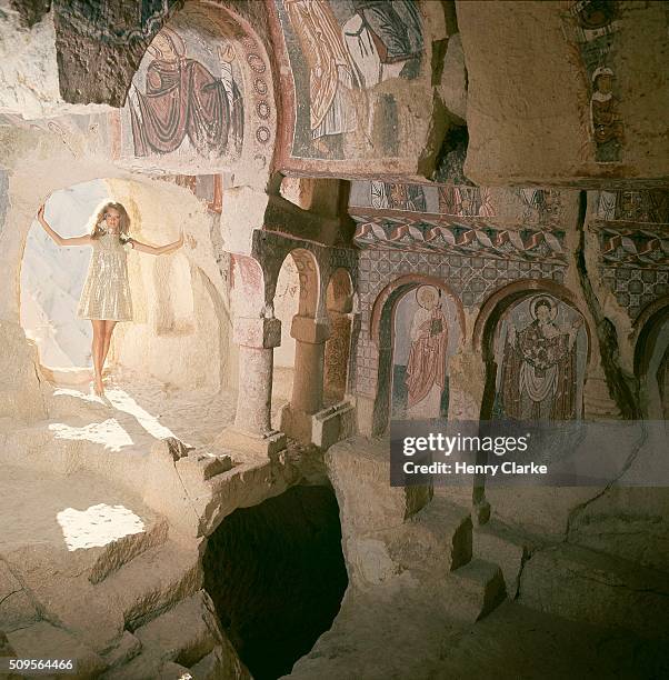 Model in Byzantine chapel in Turkey wearing gold and silver lace small-bodiced dress by Pat Sandler.