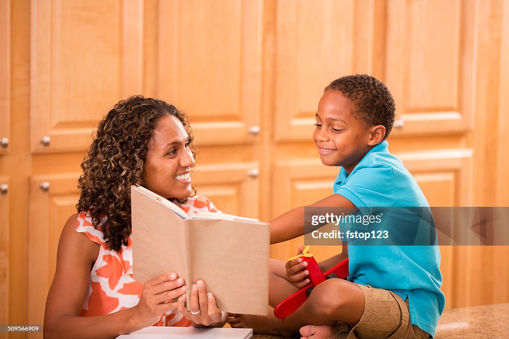 African descent mother and son doing homework together at home.