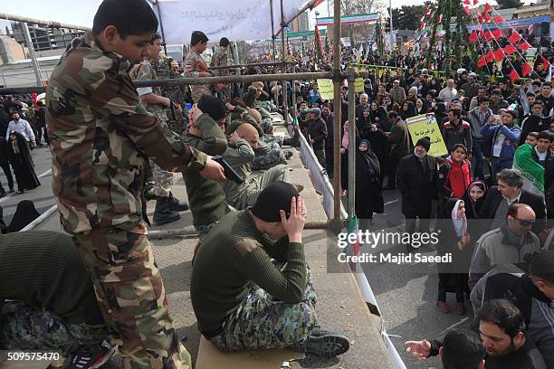 Members of Iranian Basij paramilitary force reenact the January capture of U.S sailors by the Revolutionary Guard in the Persian Gulf at a rally to...