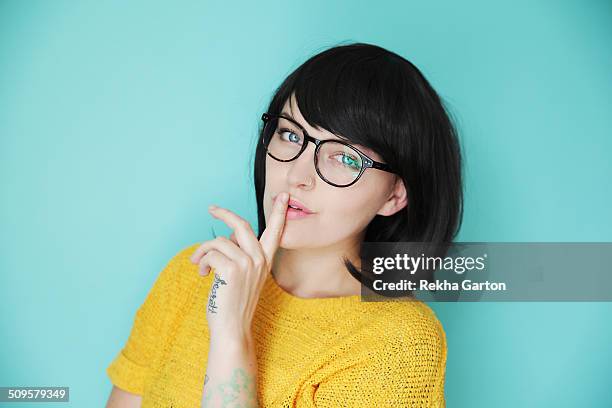 colourful young woman with finger to her lips - woman hush stock pictures, royalty-free photos & images