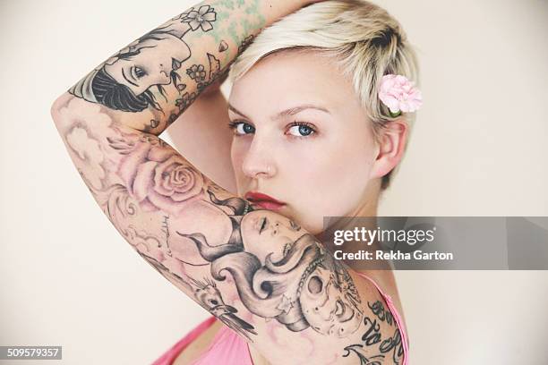 heavily tattooed woman wearing a flower - tatoo foto e immagini stock