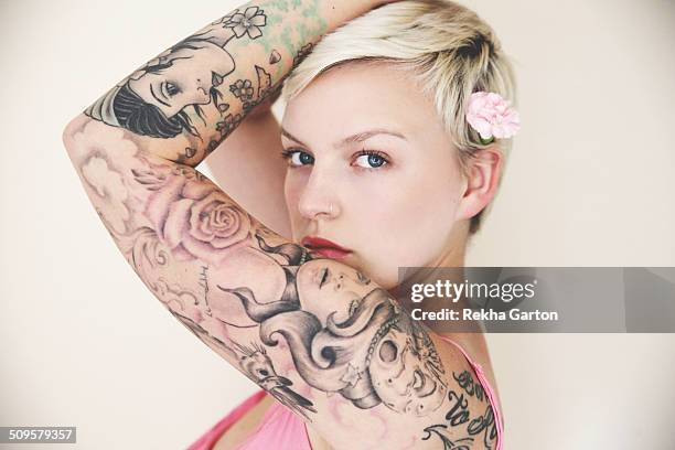 heavily tattooed woman wearing a flower - heavily tattooed women stockfoto's en -beelden