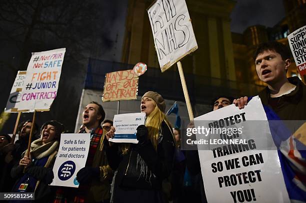 Demonstrators including junior doctors gather with placards outside the Department of Health on Whitehall in central London on February 11 to protest...