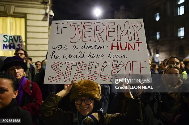 Demonstrator holds a placard mentioning British Health Secretary Jeremy Hunt as she joins others including junior doctors outside the Department of...