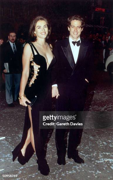 British actor Hugh Grant and his girlfriend Elizabeth Hurley attend the premiere of Grant's latest film, 'Four Weddings and a Funeral' in London,...