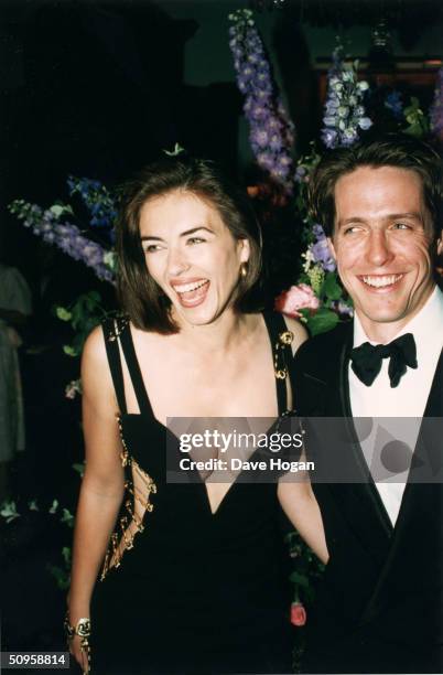 British actor Hugh Grant and his girlfriend Elizabeth Hurley attend the post-premiere party of Grant's latest film, 'Four Weddings and a Funeral' in...