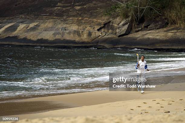 Torchbearer Janeth Arcain, Brazilian Olympic basketball player, carries the Olympic Flame on Praia Vermelha during the ATHENS 2004 Olympic Torch...