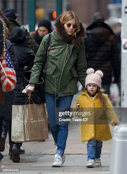 Sienna Miller stopping to get her daughter a cupcake while taking a walk through Soho on February 09, 2016 in New York City.